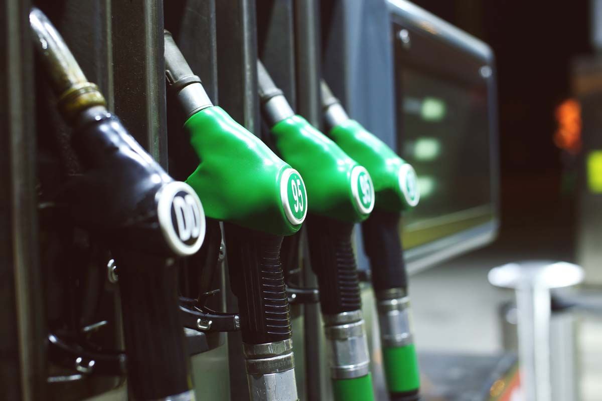 A row of green gas pumps with a green nozzle, ready to fuel vehicles efficiently and sustainably.